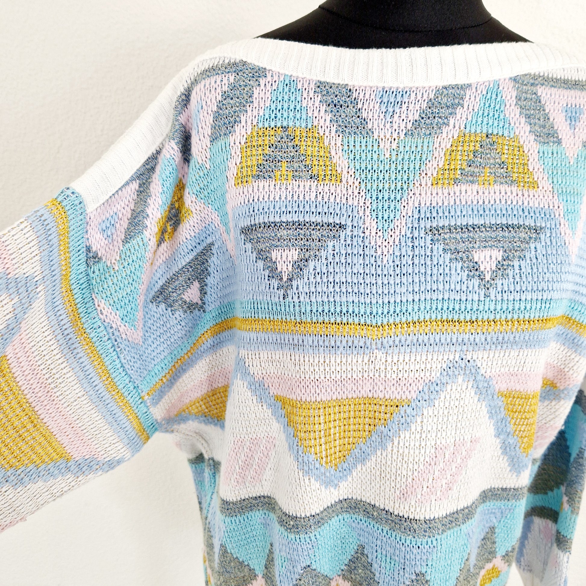 Einzigartiger und nachhaltiger Vintage Pullover in weiss-rosa-gelb, geometrisch. Unique and sustainable vintage pullover in white-pink-yellow, geometric. Close-up.