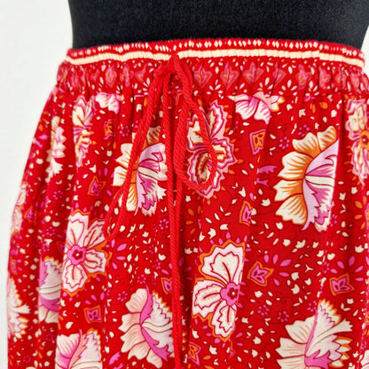 Einzigartiger und nachhaltiger Vintage Rock in rot-pink-gelb mit Blumen und Jaguar. Unique and sustainable vintage skirt in red-pink-yellow with flowers and jaguar. Close-up.