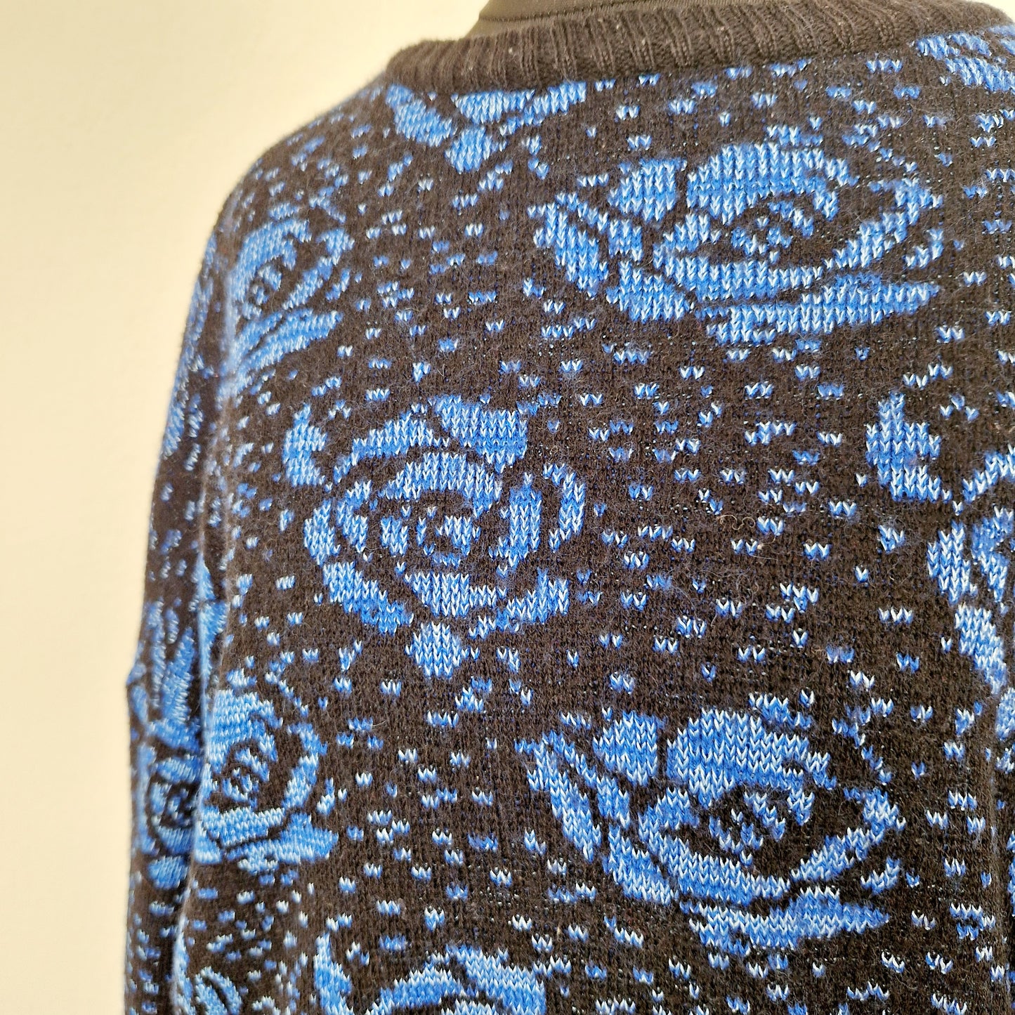 Einzigartiger und nachhaltiger Vintage Pullover in blau mit Rosen. Unique and sustainable vintage pullover in blue with roses. Close-up.