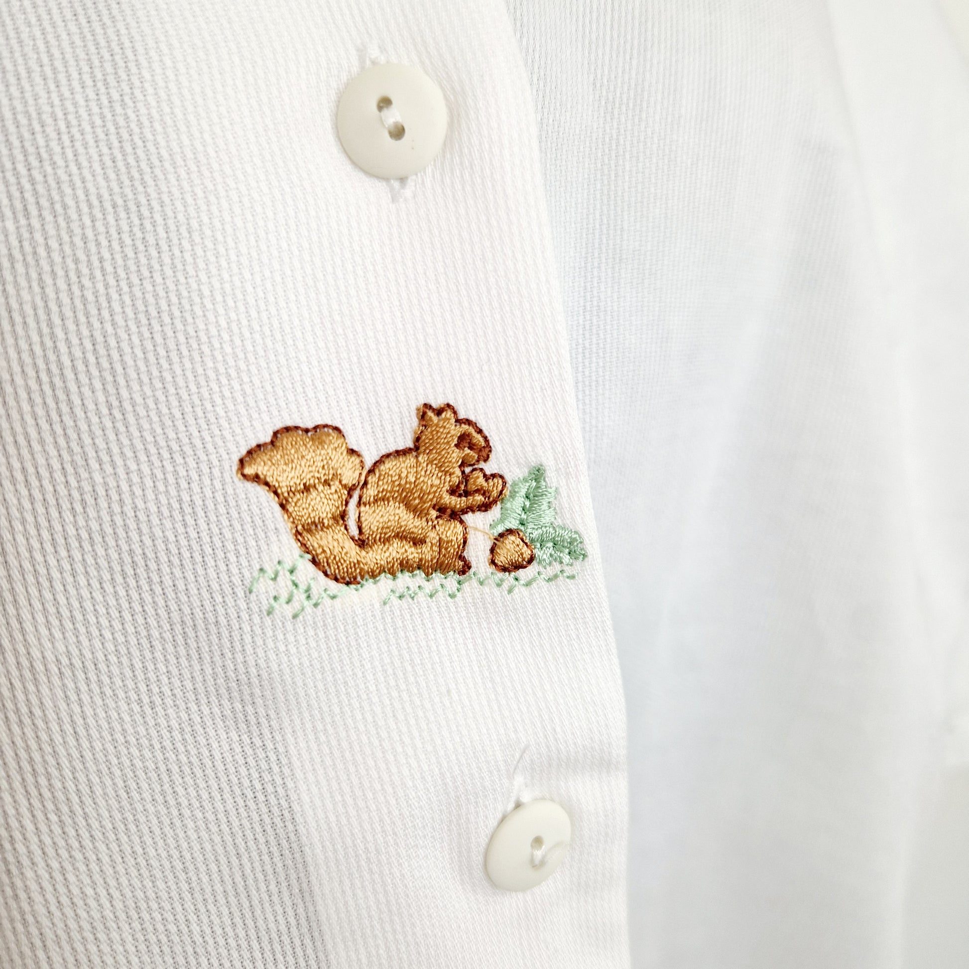 Einzigartige und nachhaltige Vintage Bluse in weiss mit Eichhörnchen. Unique and sustainable vintage blouse in white with squirrel. Close-up.