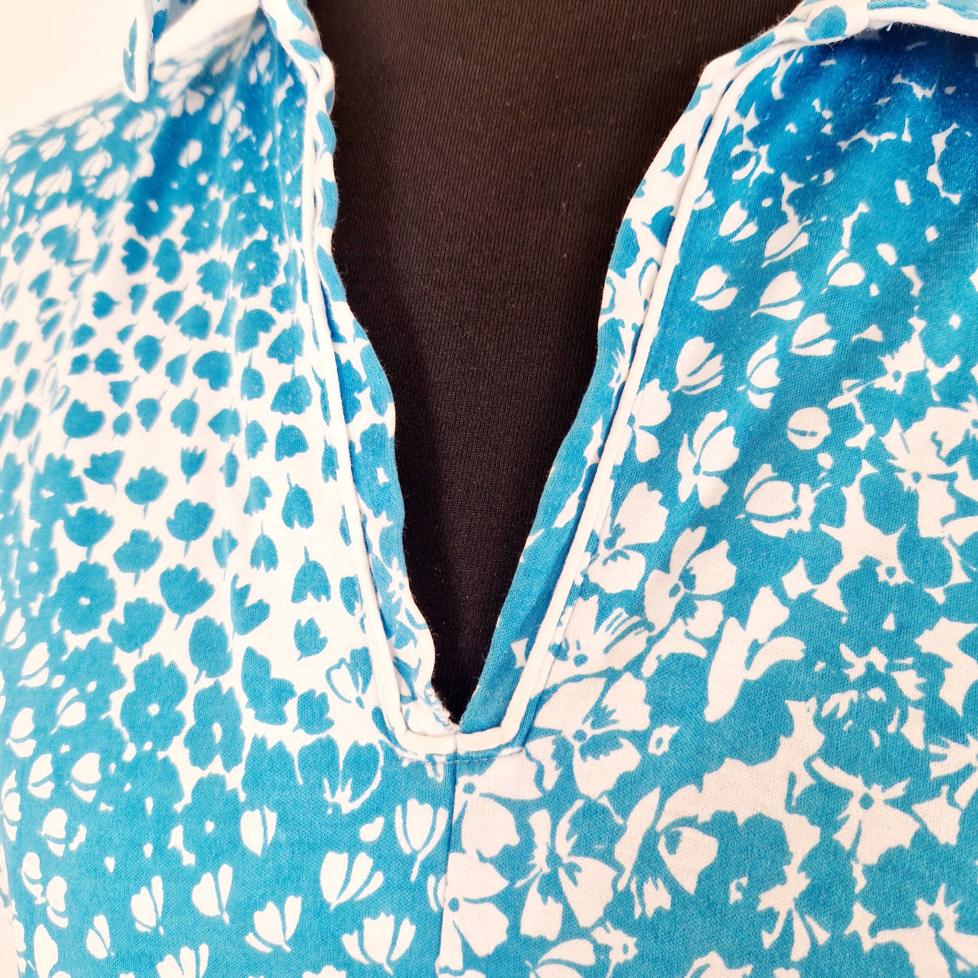 Einzigartiges und nachhaltiges Vintage Kleid, Kurzarm, in türkis-weiss mit Blumen. Unique and sustainable vintage dress, short sleeves, in turquoise-white with flowers. Close-up.