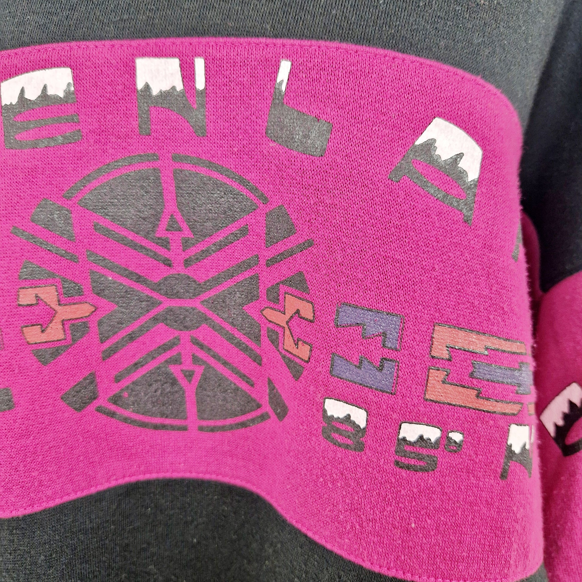 Einzigartiger und nachhaltiger Vintage Pullover in schwarz-fuchsia. Unique and sustainable vintage sweater in black-fuchsia. Close-up.