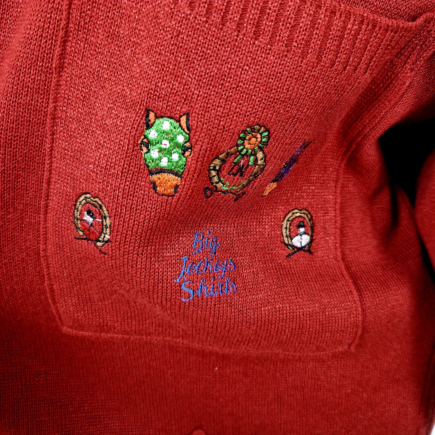 Einzigartiger und nachhaltiger Vintage Cardigan in rot mit Pferden. Unique and sustainable vintage cardigan in red with horses. Close-up.