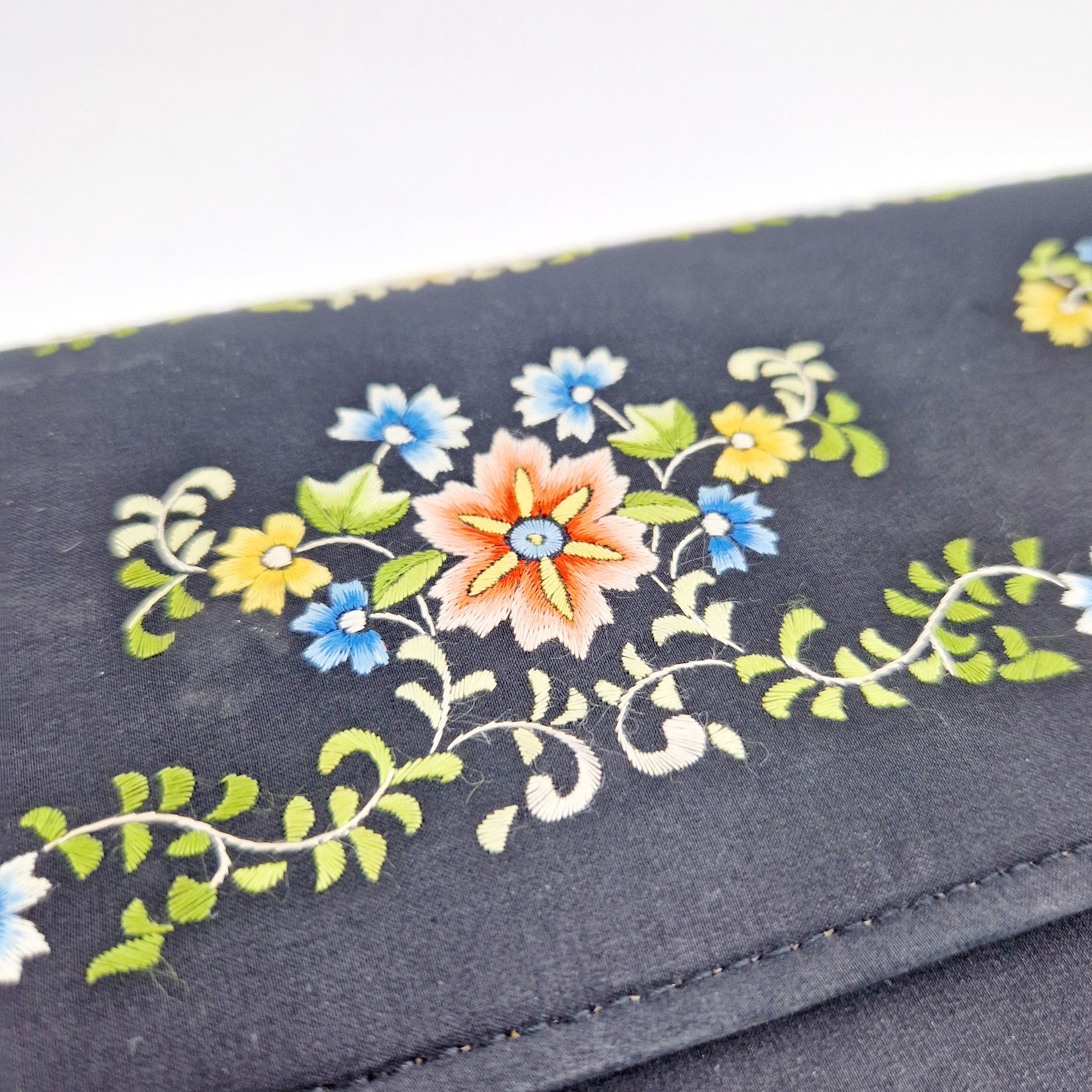 Einzigartige und nachhaltige Vintage Clutch in schwarz mit Blumen. Unique and sustainable vintage clutch in black-with flowers. Close-up.