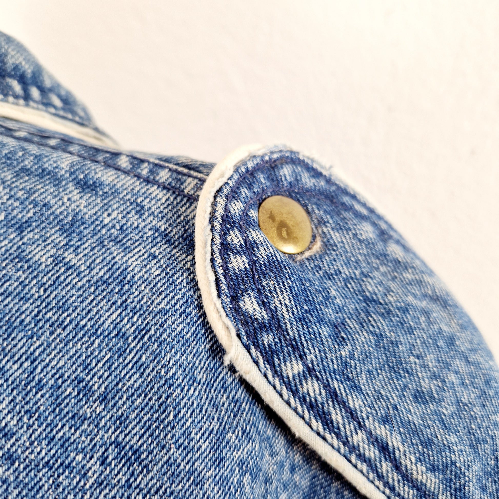 Einzigartige und nachhaltige Vintage Jeans Jacke, 80s Style. Unique and sustainable vintage jeans jacket, 80s style. Close-up.