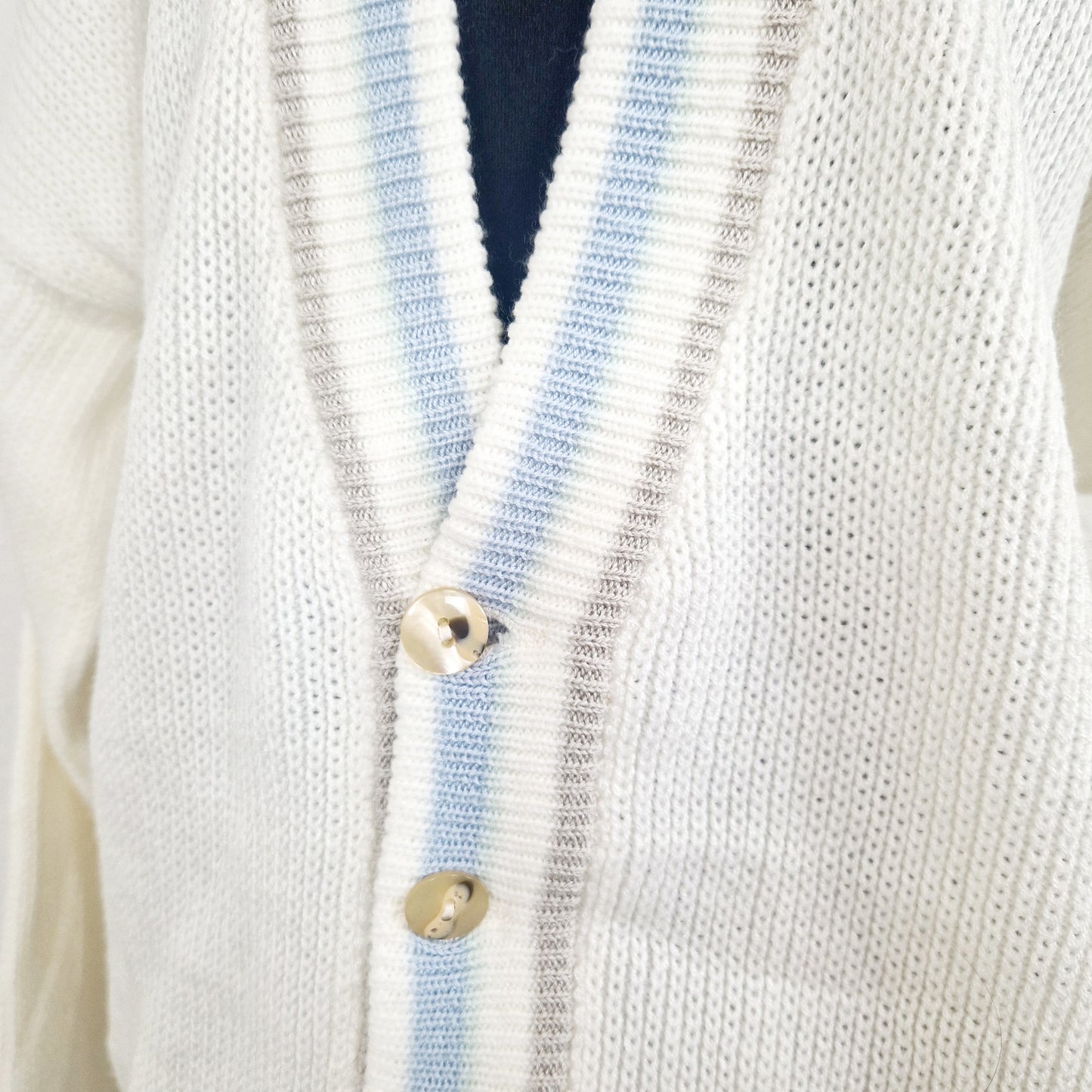 Einzigartiger und nachhaltiger Vintage Cardigan in weiss un hellblau. Unique and sustainable vintage cardigan in white and light blue. Close-up.