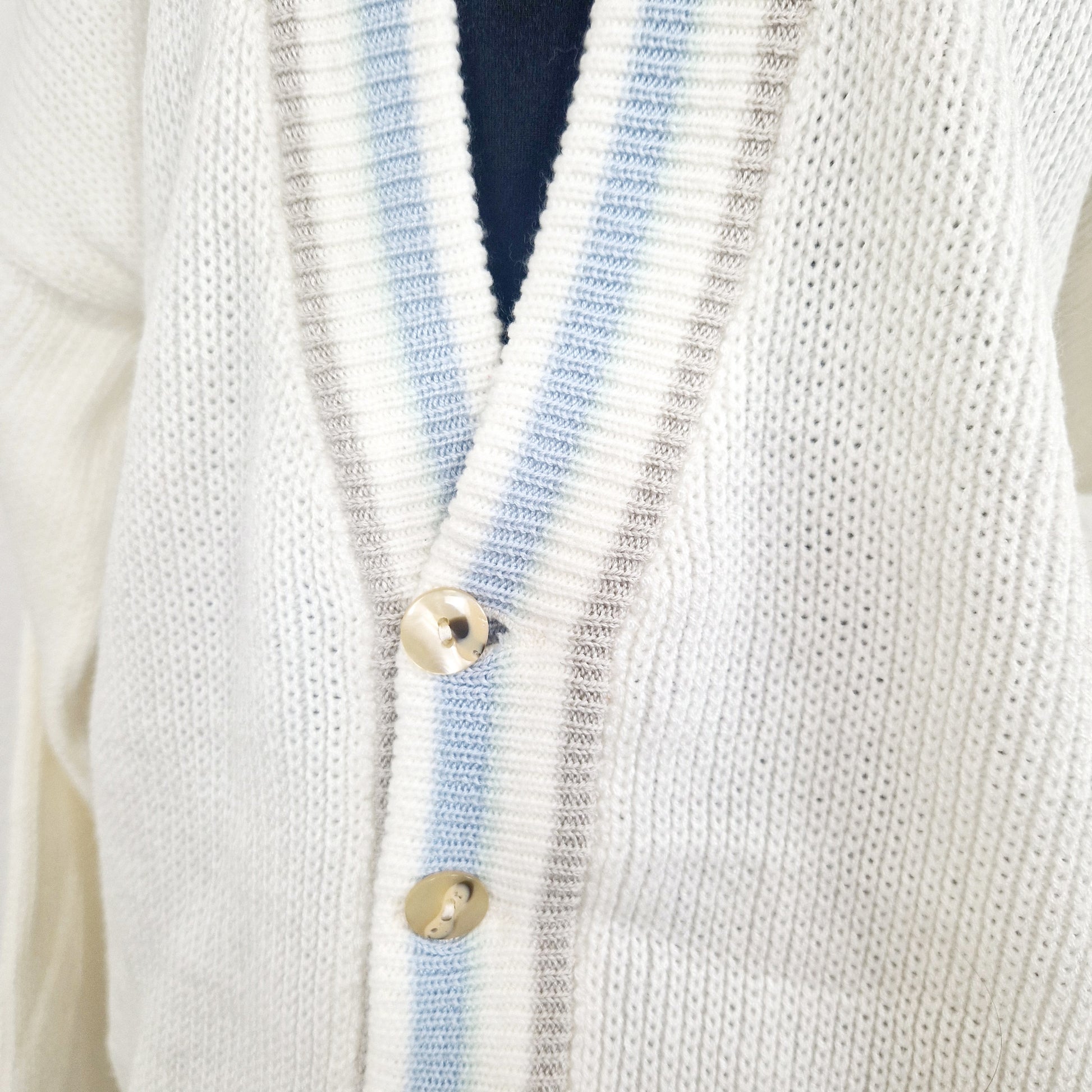 Einzigartiger und nachhaltiger Vintage Cardigan in weiss un hellblau. Unique and sustainable vintage cardigan in white and light blue. Close-up.