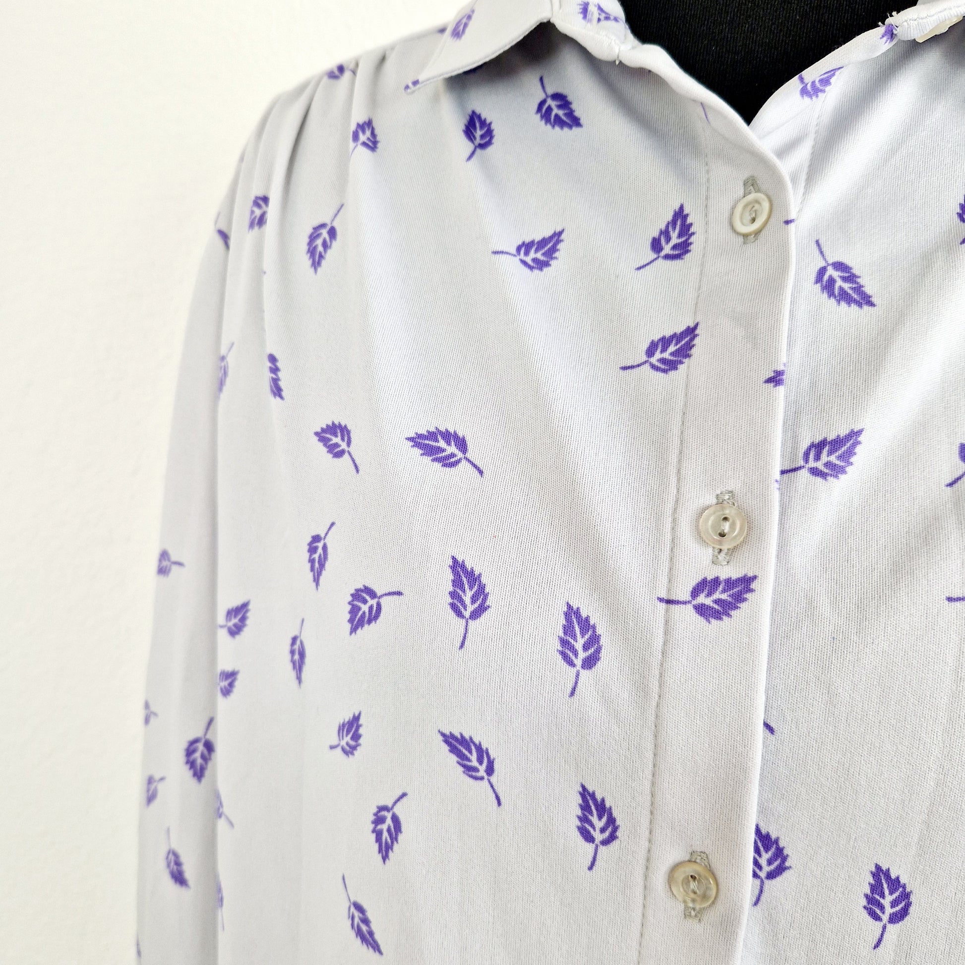 Einzigartige und nachhaltige Vintage Bluse in hellgrau-violett mit Blättern. Unique and sustainable vintage blouse in light grey-purple with leaves. Close-up.