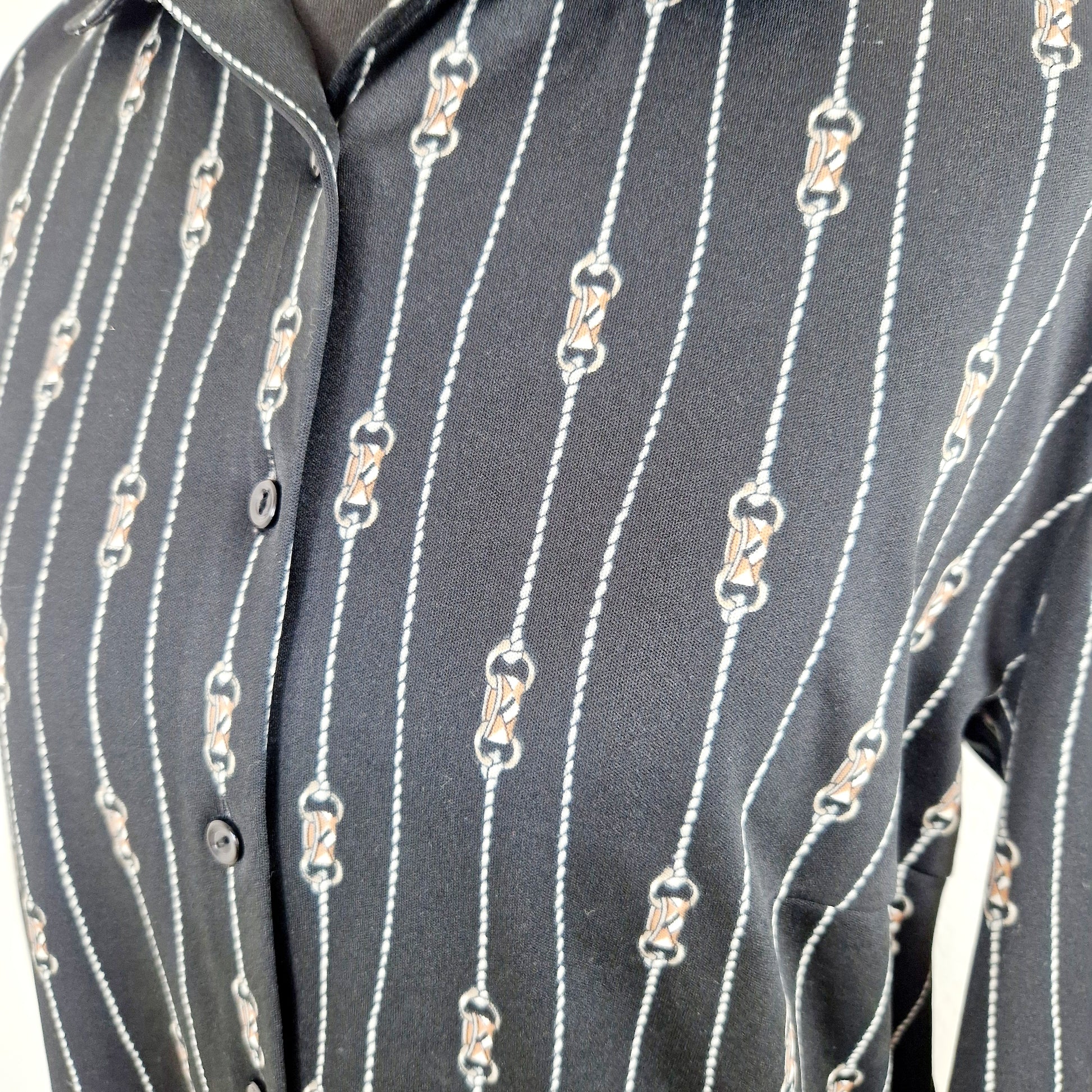 Einzigartige und nachhaltige Vintage Bluse in schwarz mit Reiterdetails. Unique and sustainable vintage blouse in black with horse riding details. Close-up.