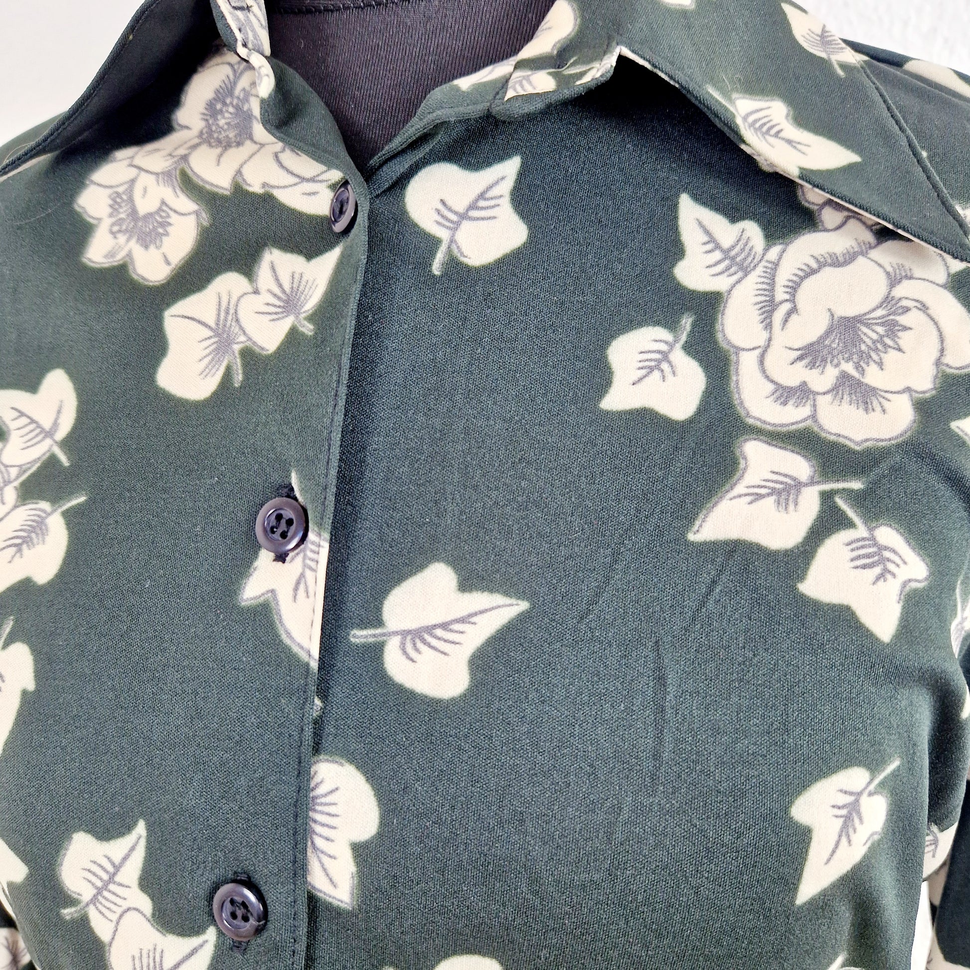 Einzigartige und nachhaltige Vintage Bluse in schwarz-eierschale mit Efeu. Unique and sustainable vintage blouse in black-off-white with ivy. Close-up.