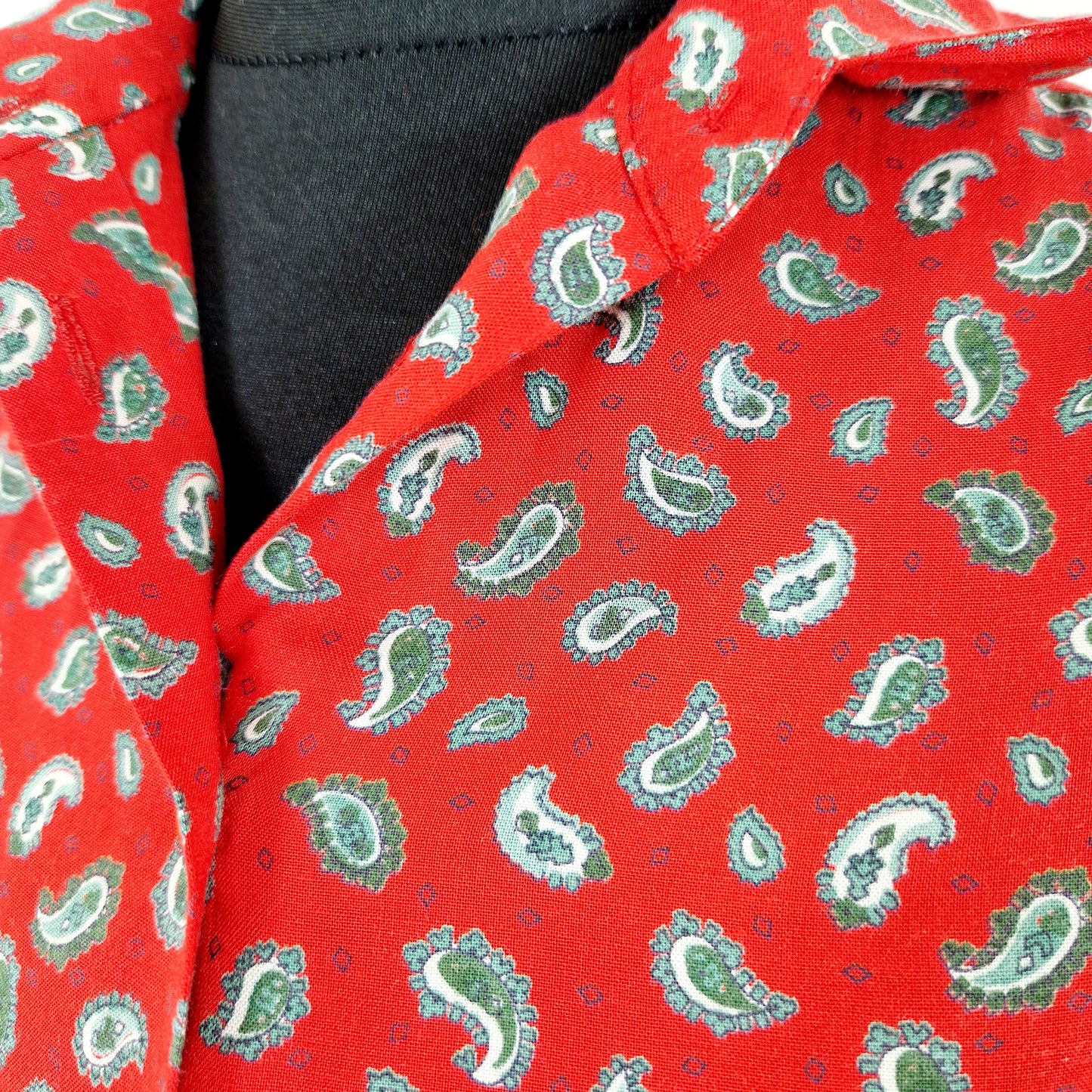 Einzigartige und nachhaltige Vintage Bluse in rot mit Paisley-Muster. Unique and sustainable vintage blouse in red with paisley pattern. Close-up.