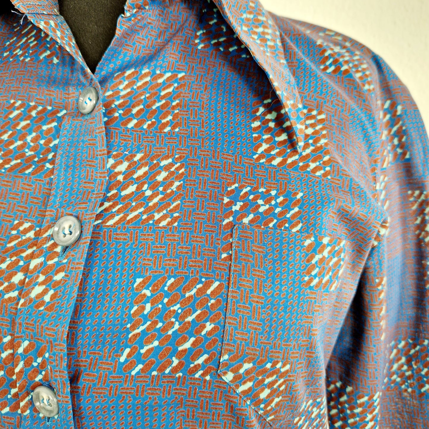 Einzigartige und nachhaltige Vintage Bluse in blau-braun-mint, geometrisch. Unique and sustainable vintage blouse in blue-brown-mint, geometric. Close-up.