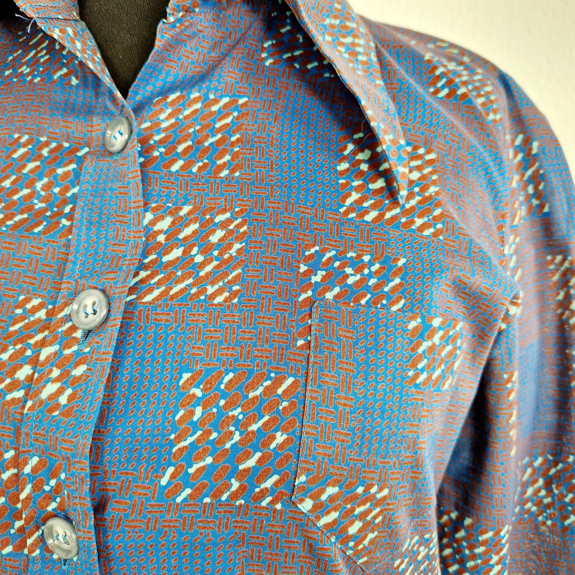 Einzigartige und nachhaltige Vintage Bluse in blau-braun-mint, geometrisch. Unique and sustainable vintage blouse in blue-brown-mint, geometric. Close-up.