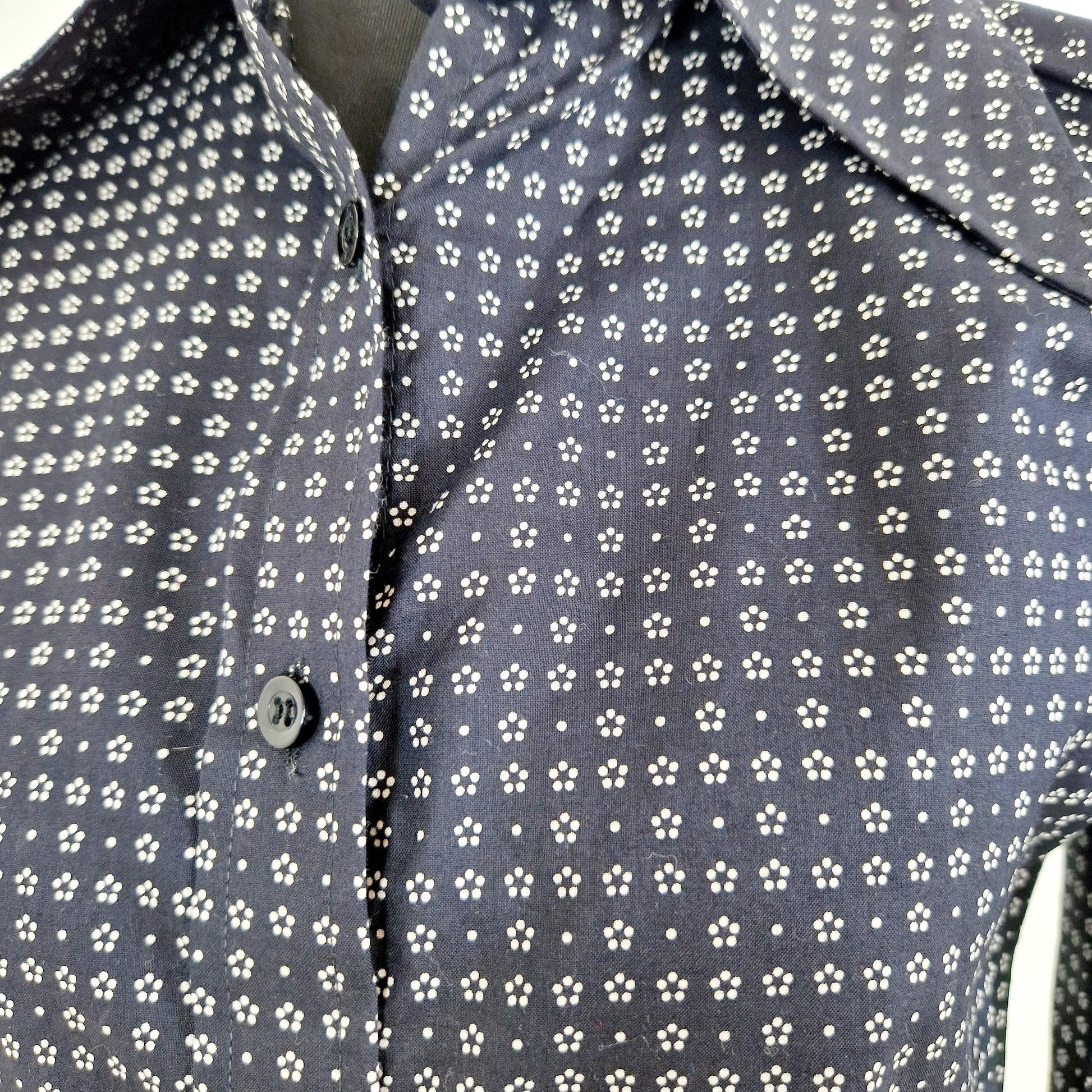 Einzigartige und nachhaltige  Vintage Bluse in dunkelblau mit weissen Blumen. Unique and sustainable vintage blouse in dark blue with white flowers. Close-up.