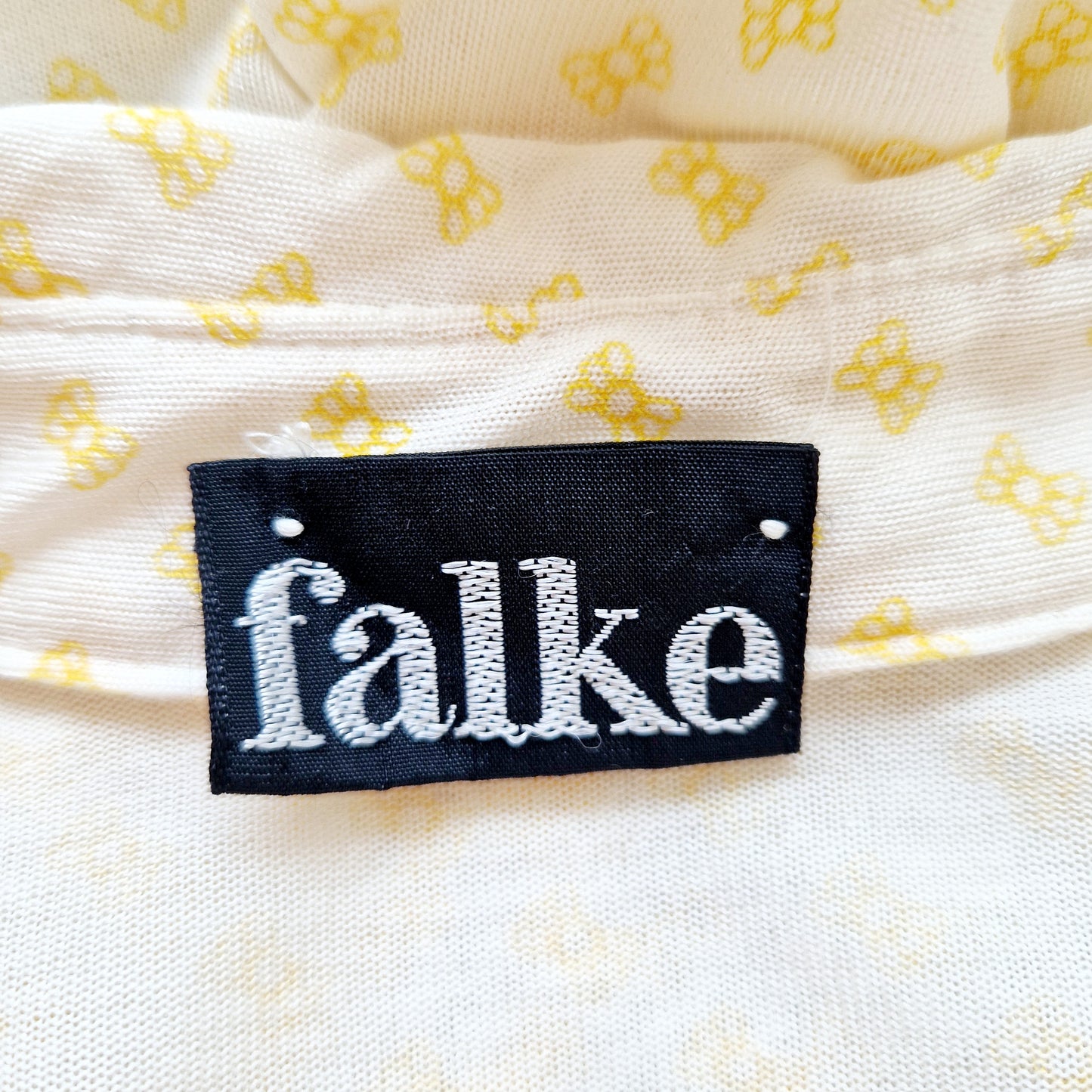 Einzigartige und nachhaltige Vintage Bluse in eierschale-gelb mit Maschen. Unique and sustainable vintage blouse in off-white-yellow with bows. Tag.