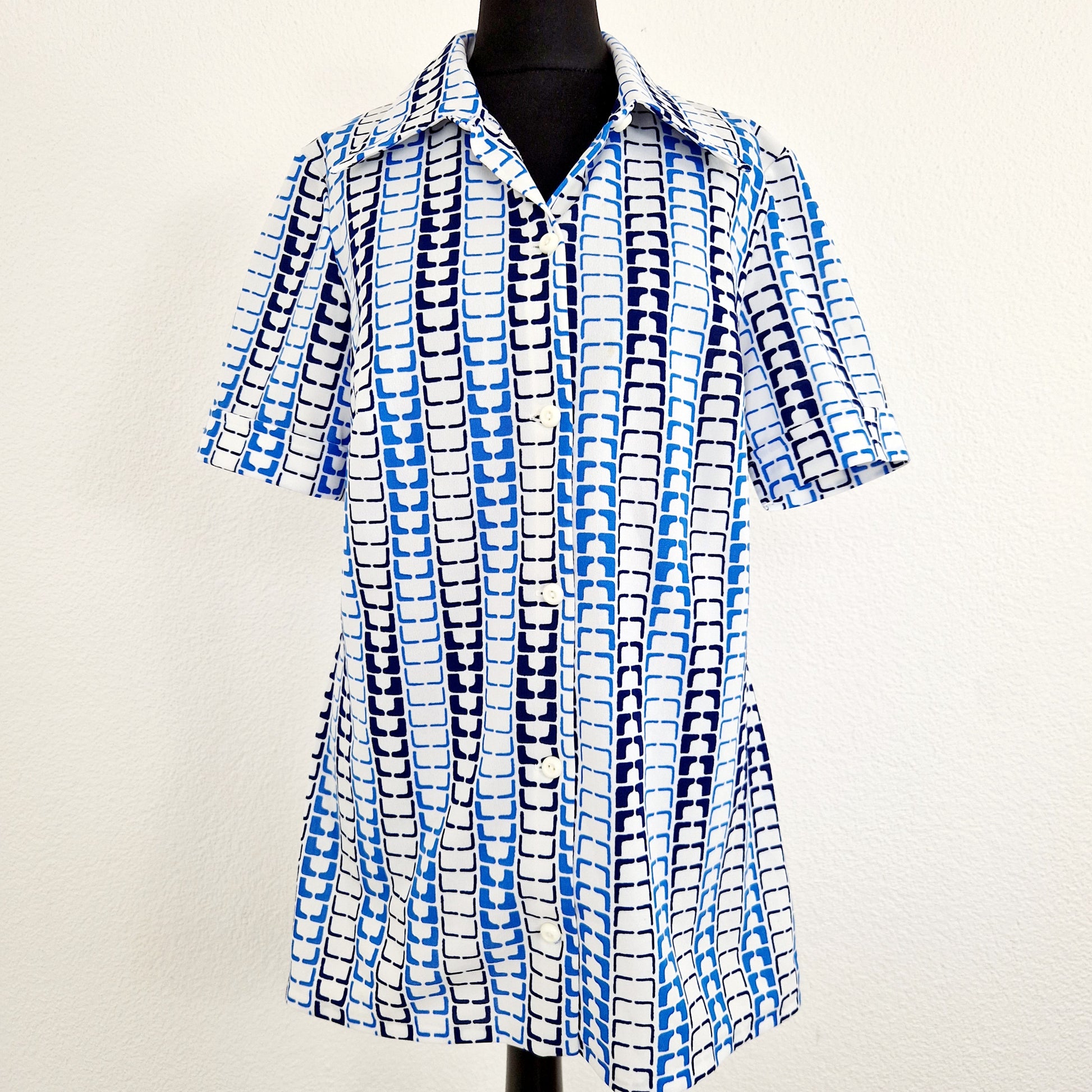 Einzigartie und nachhaltige Vintage Bluse in weiss-blau, geometrisch. Unique and sustainable vintage blouse in white-blue, geometrisch pattern. Front. 