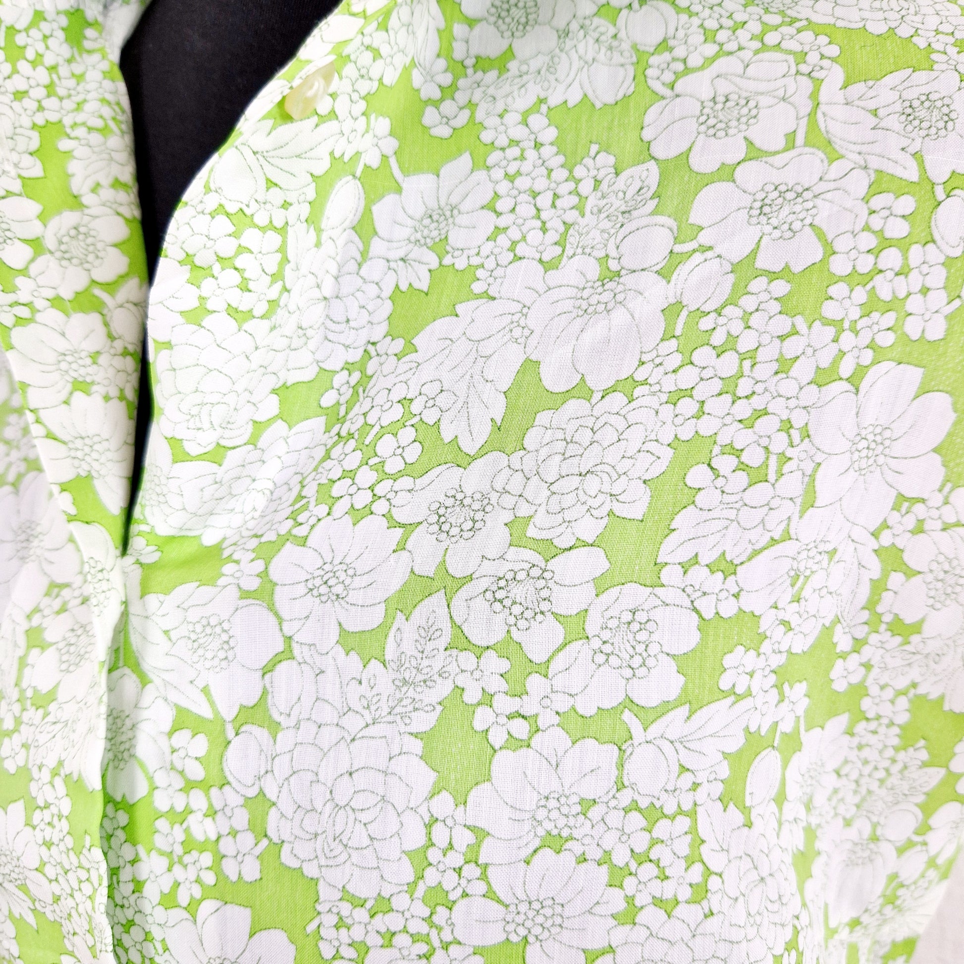 Einzigartiges und nachhaltiges Vintage Top in weiss-hellgrün mit Blumen. Unique and sustainable vintage top in white-light green with flowers. Close-up.