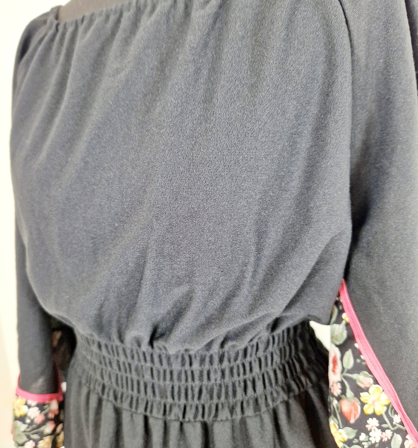 Einzigartiges und nachhaltiges Vintage Kleid in Schwarz mit Blumen und Trompetenärmeln. Unique and sustainable vintage dress in black with flowers and trompet sleeves. Close-up.