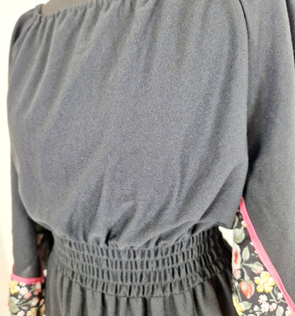 Einzigartiges und nachhaltiges Vintage Kleid in Schwarz mit Blumen und Trompetenärmeln. Unique and sustainable vintage dress in black with flowers and trompet sleeves. Close-up.