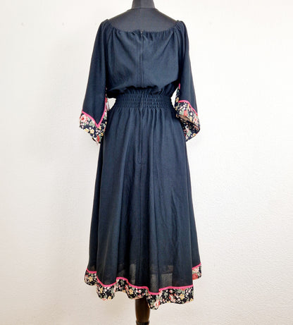 Einzigartiges und nachhaltiges Vintage Kleid in Schwarz mit Blumen und Trompetenärmeln. Unique and sustainable vintage dress in black with flowers and trompet sleeves. Back.