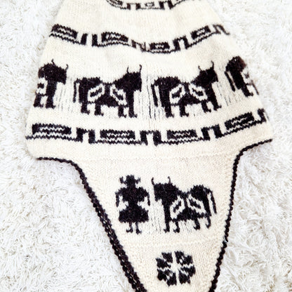 Einzigartige und nachhaltige Vintage Mütze in eierschale-dunkelbraun mit earflap und Kühen. Unique and sustainable vintage hat in offwhite-dark brown with earflap and cows. Close-up.