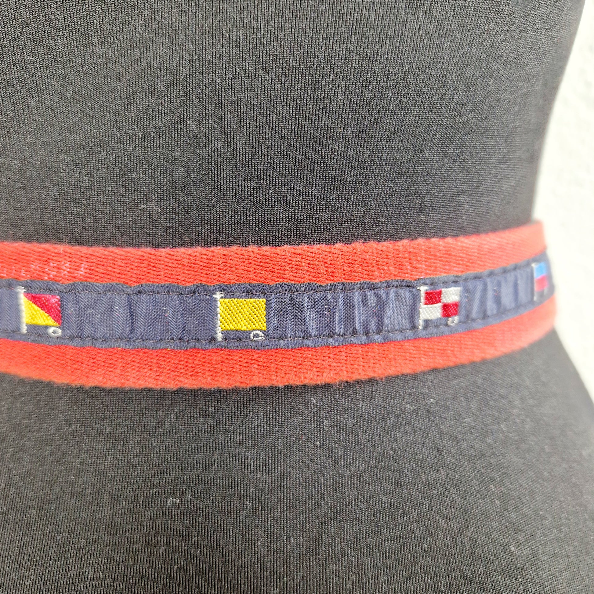 Einzigartiger und nachhaltiger Vintage Gürtel in rot-blau mit Fahnen. Unique and sustainable vintage belt in red-blue with flags. Close-up.