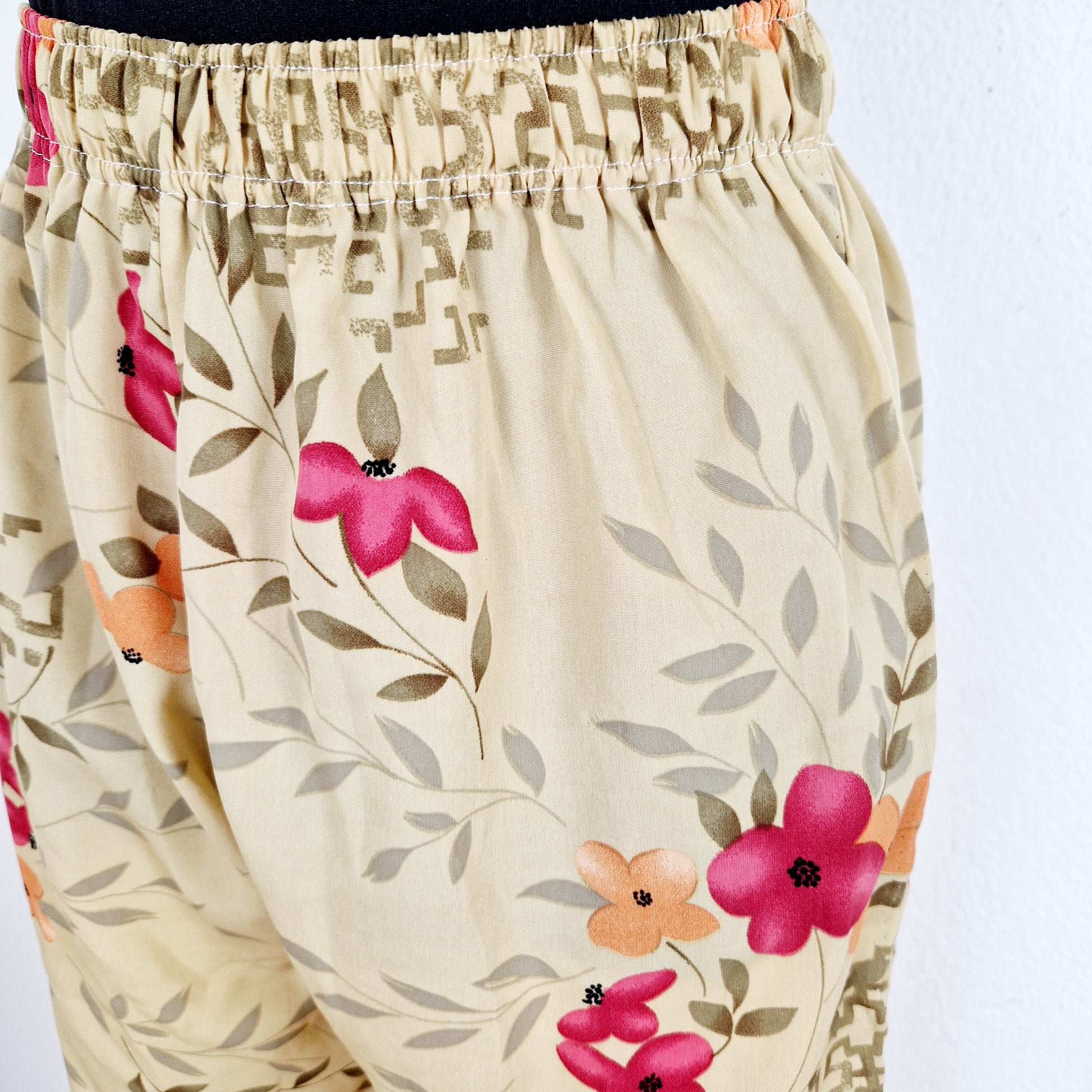 Einzigartige und nachhaltige Vintage Hose in beige-oliv-rot mit Blumen. Unique and sustainable vintage pants in beige-olive-red with flowers. Close-up.
