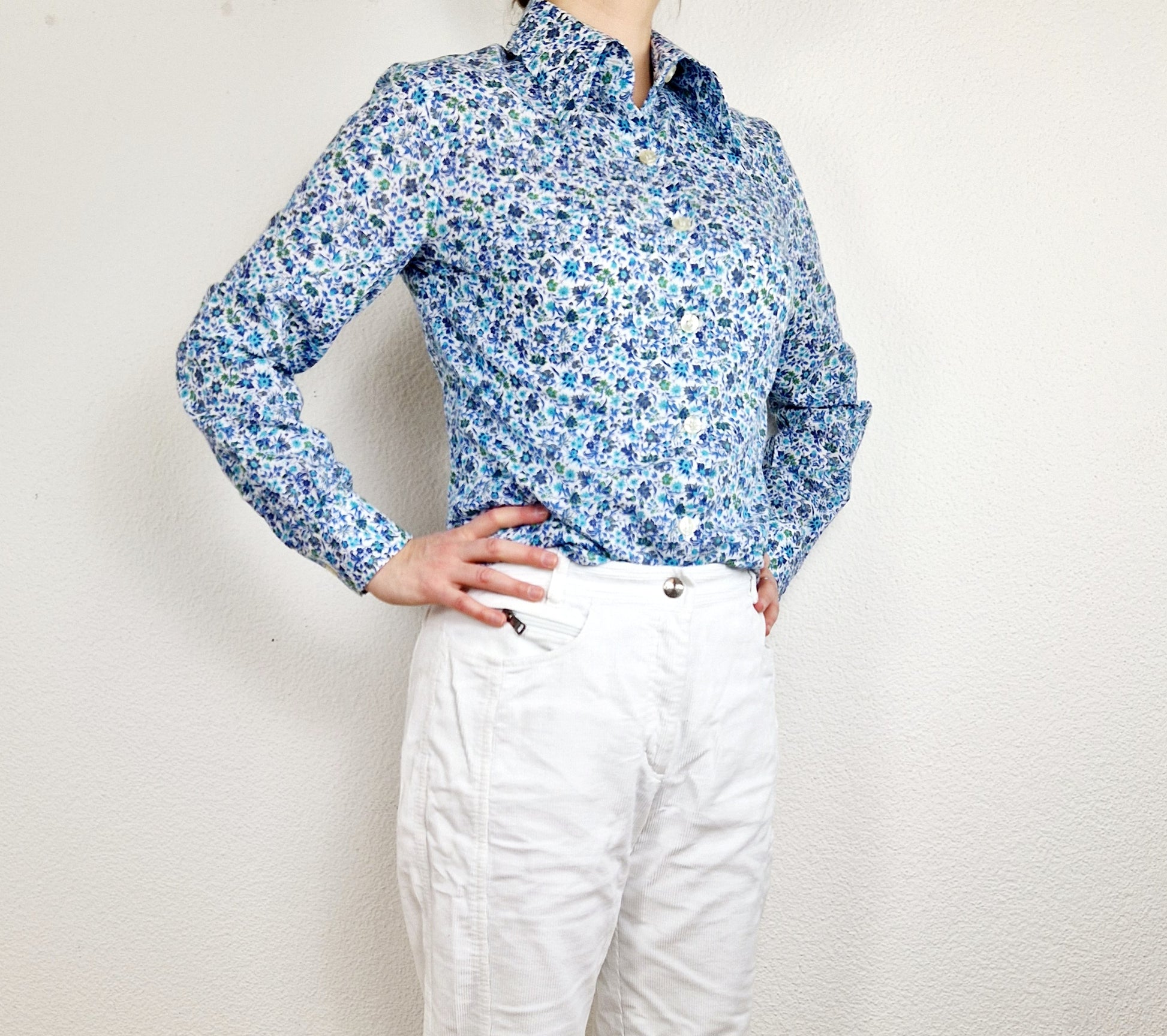Einzigartige und nachhaltige Vintage Bluse in blau-türkis-weiss mit Blumen. Unique and sustainable vintage blouse in blue-turquoise-white with flowers. Model.