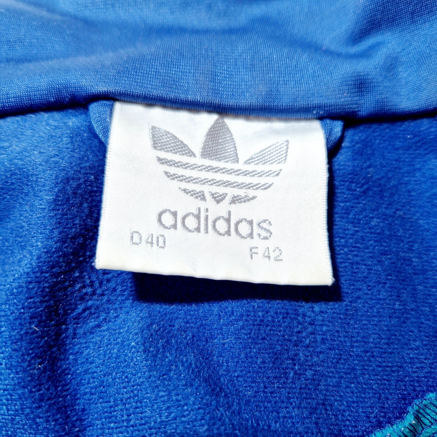 Einzigartige und nachhaltige Vintage Trainerjacke in blau-grün-rot von Adidas. Unique and sustainable vintage track jacket in blue-green-red from Adidas. Tag.