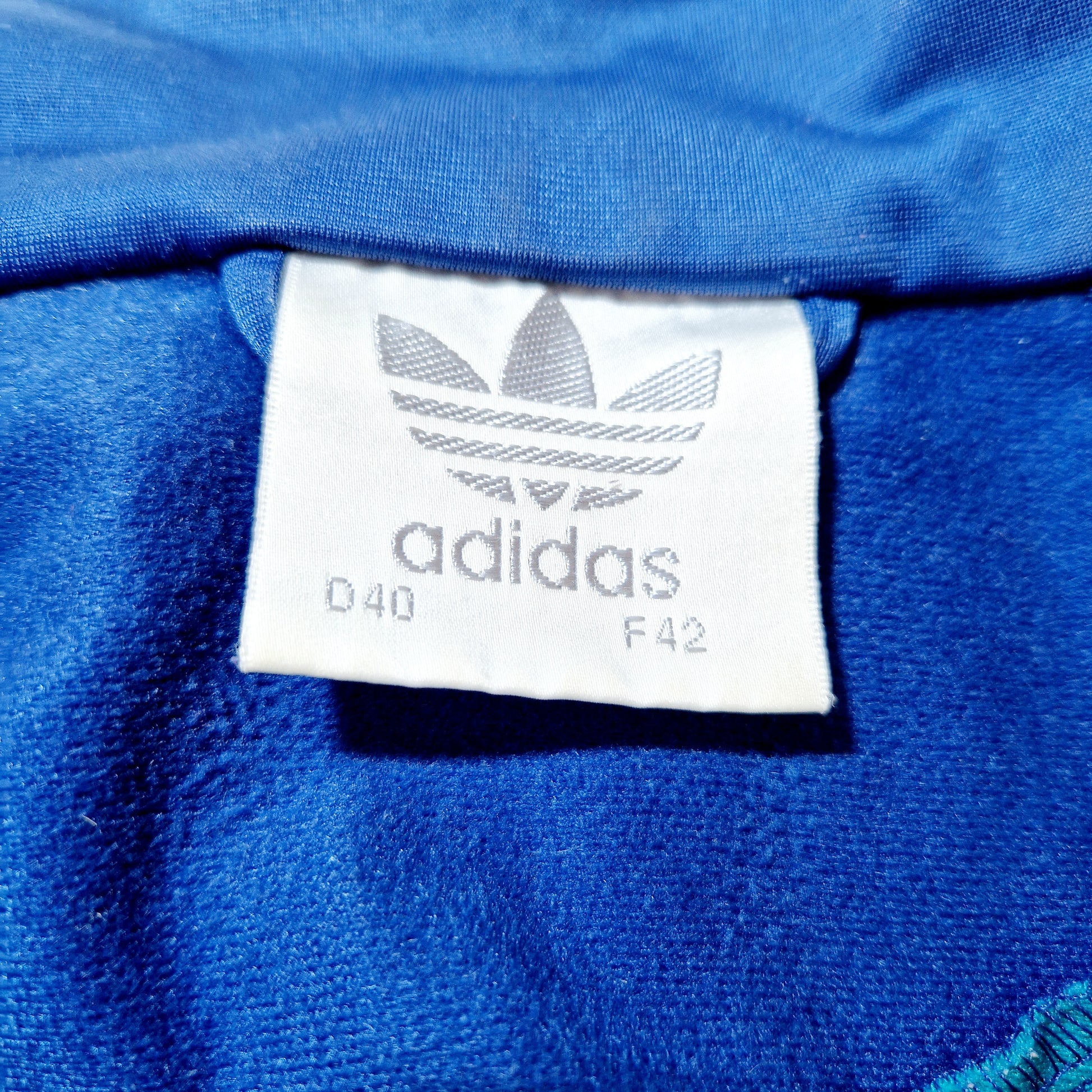 Einzigartige und nachhaltige Vintage Trainerjacke in blau-grün-rot von Adidas. Unique and sustainable vintage track jacket in blue-green-red from Adidas. Tag.
