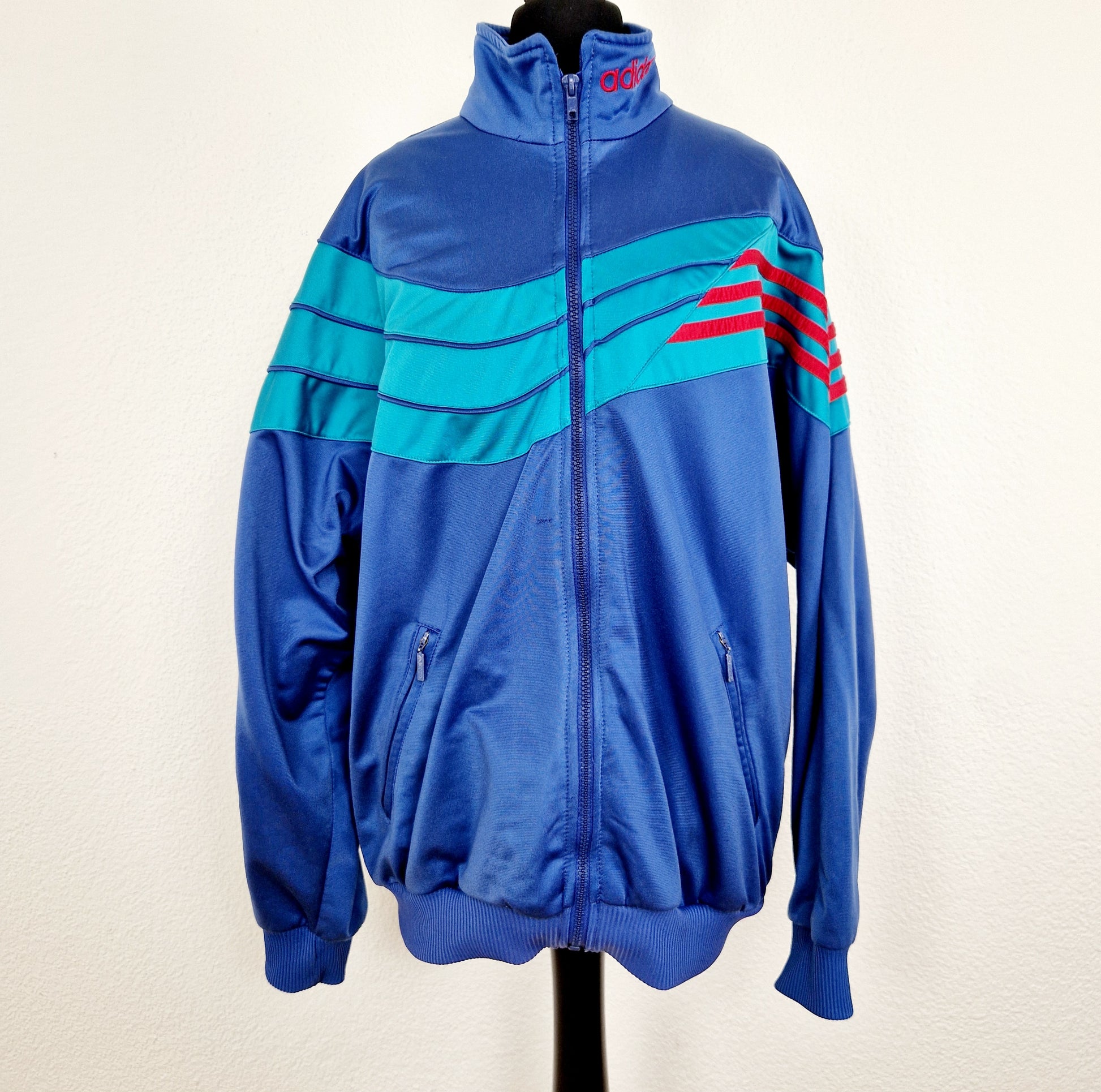 Einzigartige und nachhaltige Vintage Trainerjacke in blau-grün-rot von Adidas. Unique and sustainable vintage track jacket in blue-green-red from Adidas. Front.