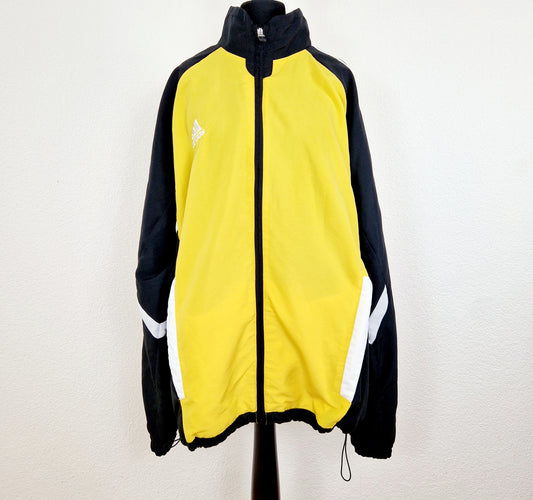 Einzigartige und nachhaltige Vintage Trainerjacke von Adidas in gelb-schwarz. Unique and sustainable vintage track jacket from Adidas in yellow-black. Front.