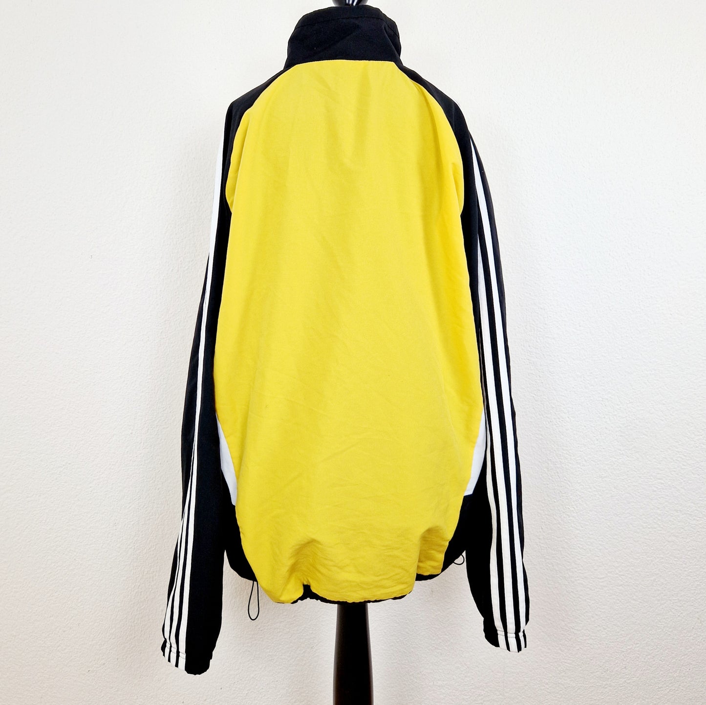 Einzigartige und nachhaltige Vintage Trainerjacke von Adidas in gelb-schwarz. Unique and sustainable vintage track jacket from Adidas in yellow-black. Back.