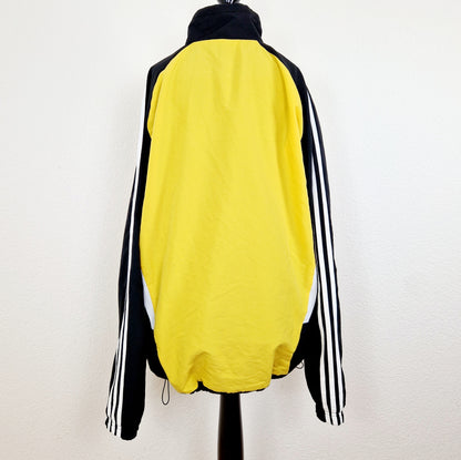 Einzigartige und nachhaltige Vintage Trainerjacke von Adidas in gelb-schwarz. Unique and sustainable vintage track jacket from Adidas in yellow-black. Back.