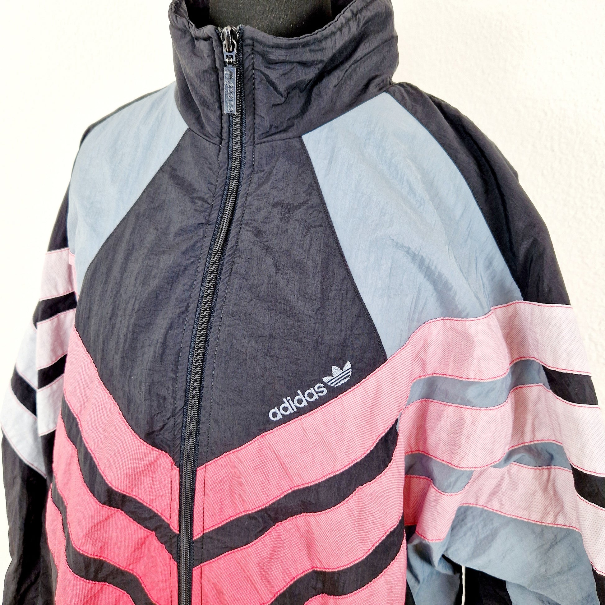 Einzigartige und nachhaltige Vintage Trainerjacke in schwarz-rot-weiss von Adidas. Unique and sustainable vintage track jacket in black-red-white from Adidas. Close-up.