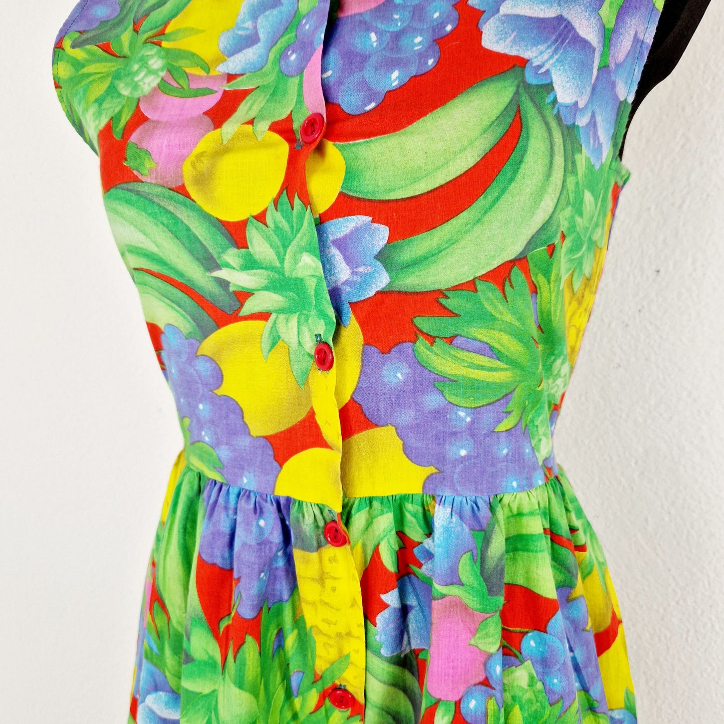 Einzigartiger und nachhaltiger Vintage Jumpsuit in hellgrün-blau-gelb mit Früchten. Unique and sustainable vintage jumpsuit in light green-blue-yellow. Close-up.