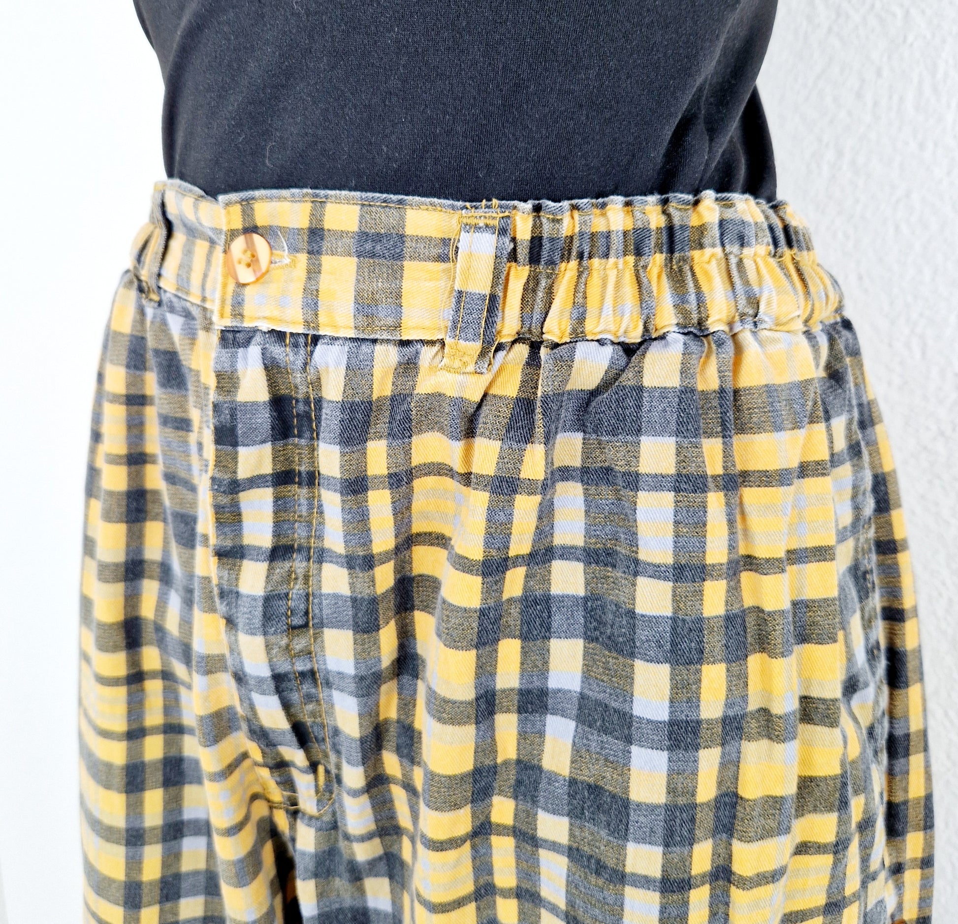 Einzigartige und nachhaltige Vintage Hose in gelb-grau kariert. Unique and sustainable vintage pants in yellow-grey, checked. Close-up.