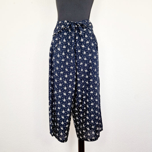 Einzigartige und nachhaltige Vintage Hose in dunkelblau-weiss mit Blumen und Gürtel. Unique and sustainable vintage pants in dark blue-white with flowers and belt. Front.