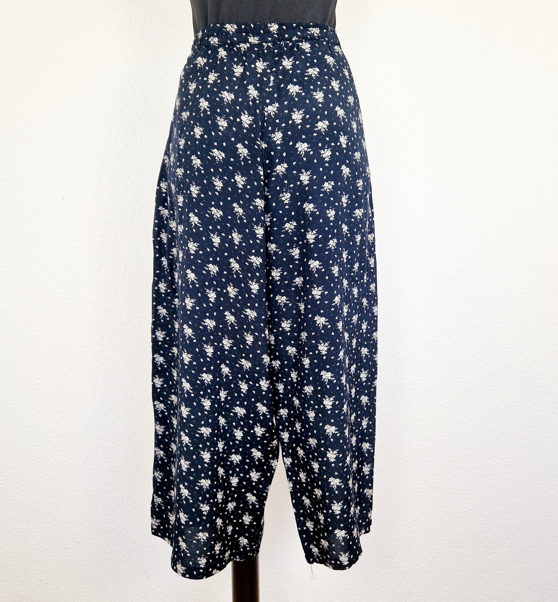 Einzigartige und nachhaltige Vintage Hose in dunkelblau-weiss mit Blumen und Gürtel. Unique and sustainable vintage pants in dark blue-white with flowers and belt. Back.
