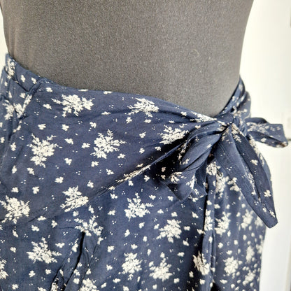 Einzigartige und nachhaltige Vintage Hose in dunkelblau-weiss mit Blumen und Gürtel. Unique and sustainable vintage pants in dark blue-white with flowers and belt. Close-up.