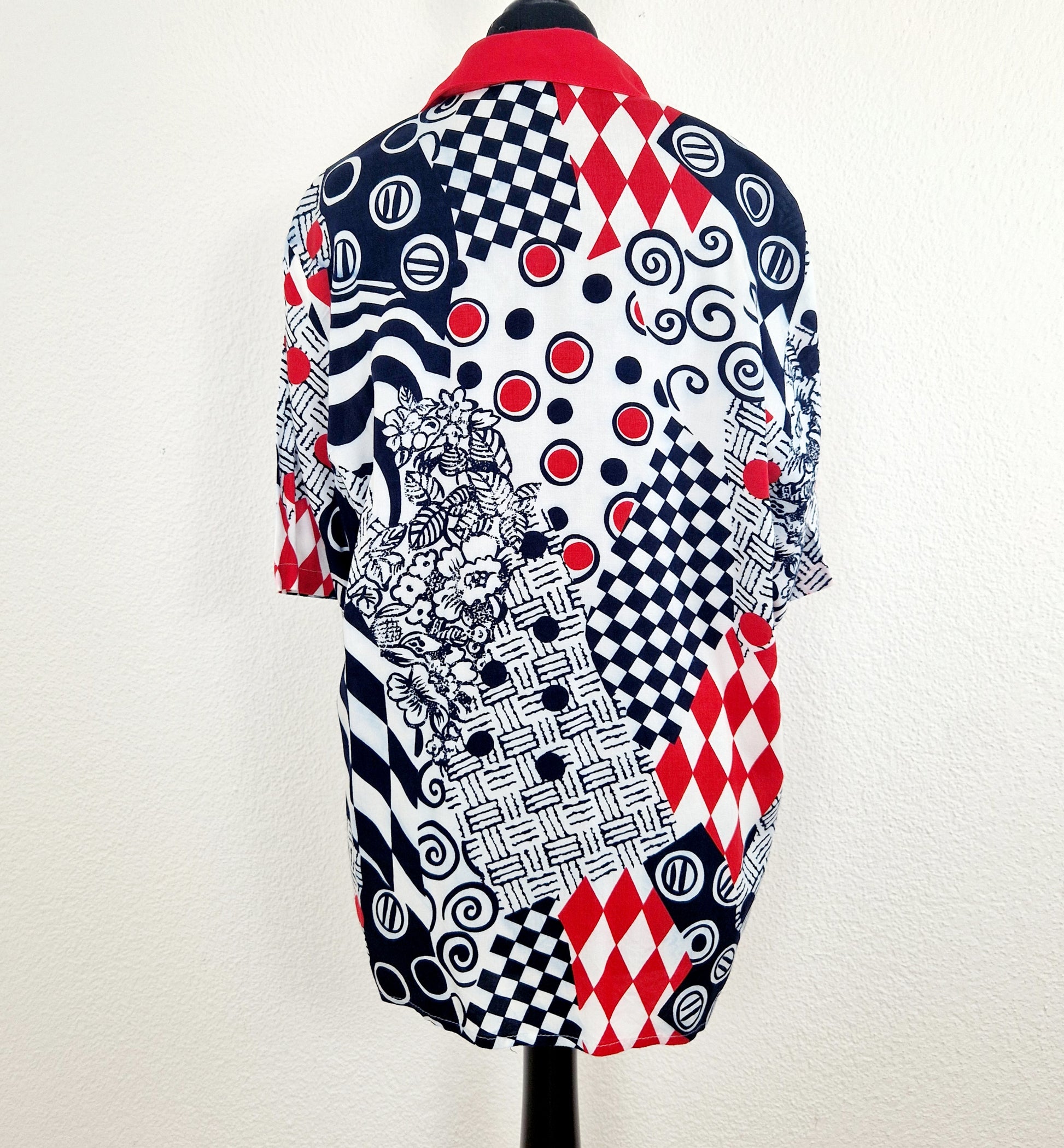 Einzigartige und nachhaltige Vintage Bluse, Kurzarm, in weiss-rot-blau, geometrisch. Unique and sustainable vintgage blouse, short sleeved, in white-red-blue, geometric. Back.