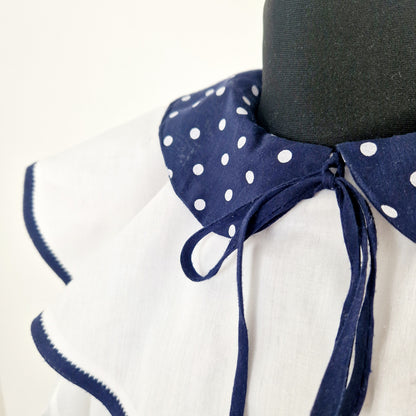 Einzigartige und nachhaltige Vintage Bluse in weiss-blau mit Kragen und Schleife. Unique and sustainable vintage blouse in white-blue with collar and bow. Close-up.