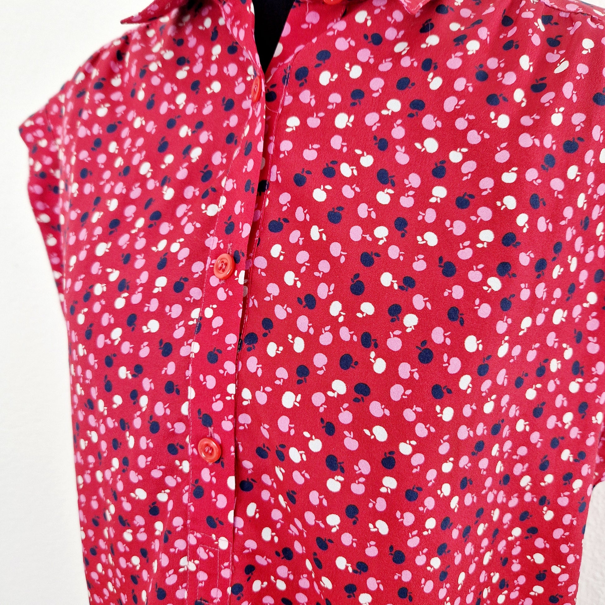 Einzigartige und nachhaltige Vintage Bluse in rot-pink-blau mit Äpfeln. Unique and sustainable vintage blouse in red-pink-blue with apples. Close-up.