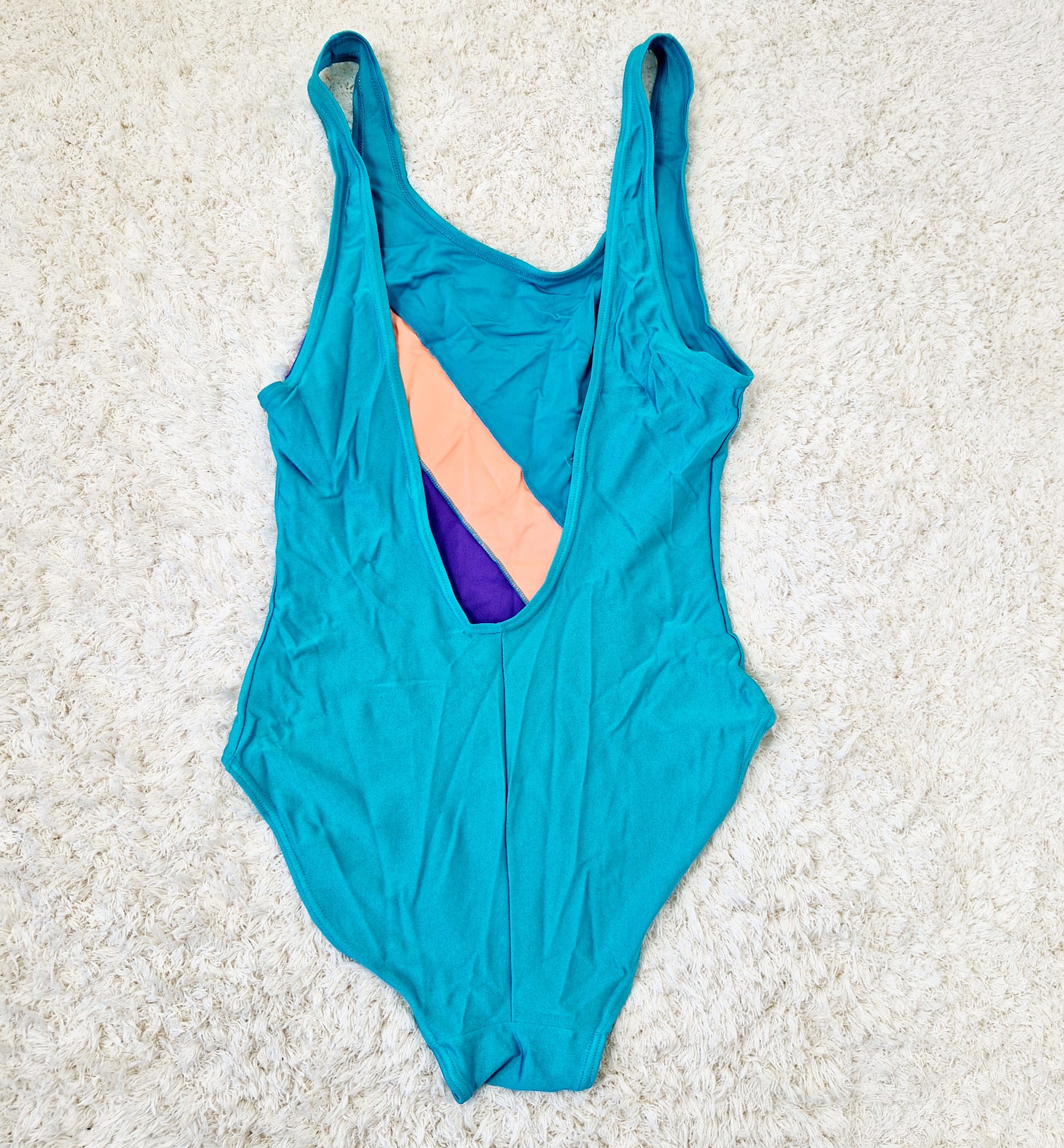 Einzigartiger und nachhaltiger Vintage Badeanzug in türkis-lachs-violett mit Streifen. Unique and sustainable vintage swimsuit in turquois-salmon-purple with stripes. Back.