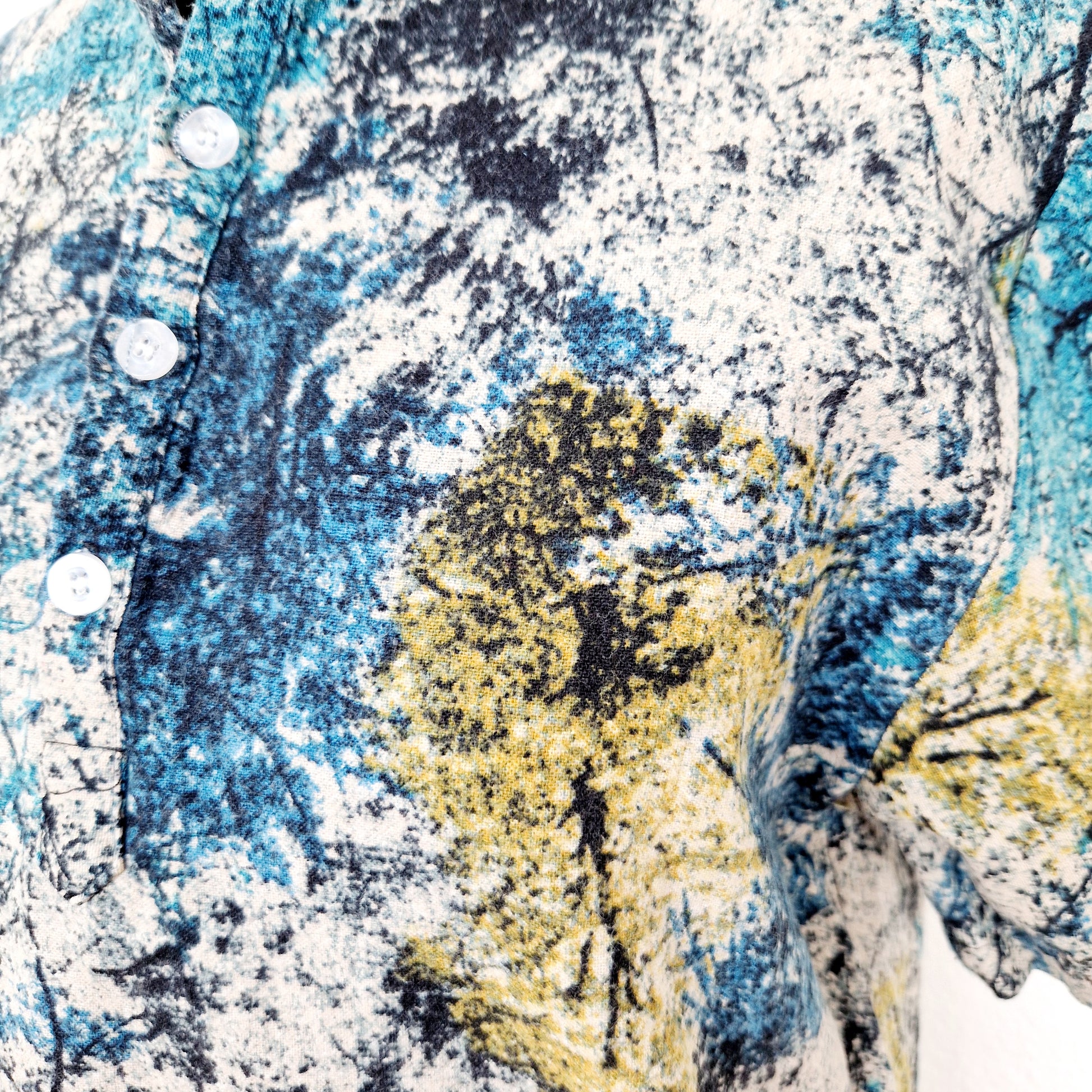 Einzigartiges und nachhaltiges Vintage T-Shirt in petrol-sand-ocker mit Bäumen. Close-up.