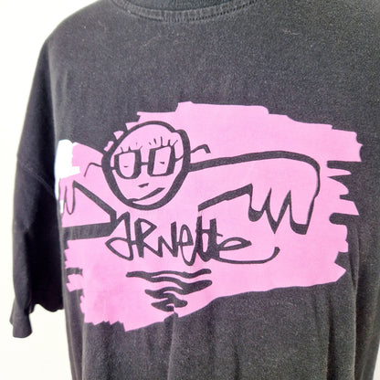 Einzigartiges und nachhaltiges Vintage T-Shirt in schwarz-pink-weiss mit einer Person mit Brille. Close-up.