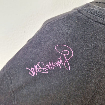 Einzigartiges und nachhaltiges Vintage T-Shirt in schwarz-pink-weiss mit einer Person mit Brille. Close-up 2.