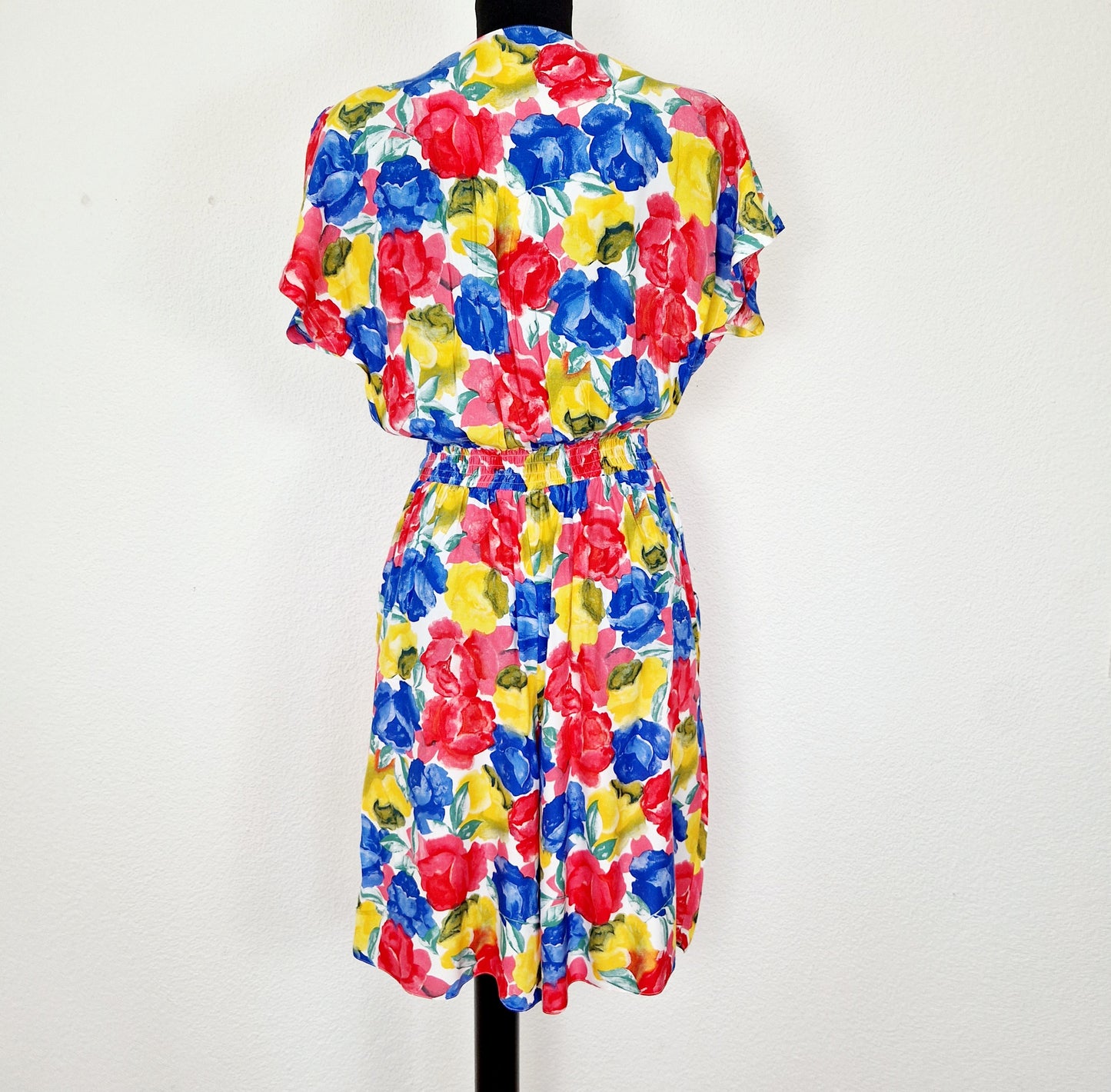 Einzigartiger und nachhaltiger Vintage Playsuit in rot-gelb-blau mit Blumen. Unique and sustainable vintage playsuit in red-yellow-blue with flowers. Back.