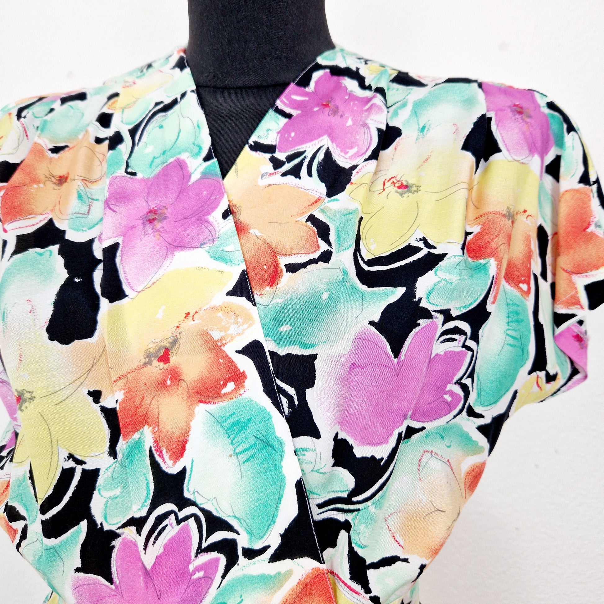 Einzigartiger und nachhaltiger Vintage Playsuit in mint-gelb-lachs mit Blumen. Unique and sustainable vintage playsuit in mint-yellow-salmon with flowers. Close-up.