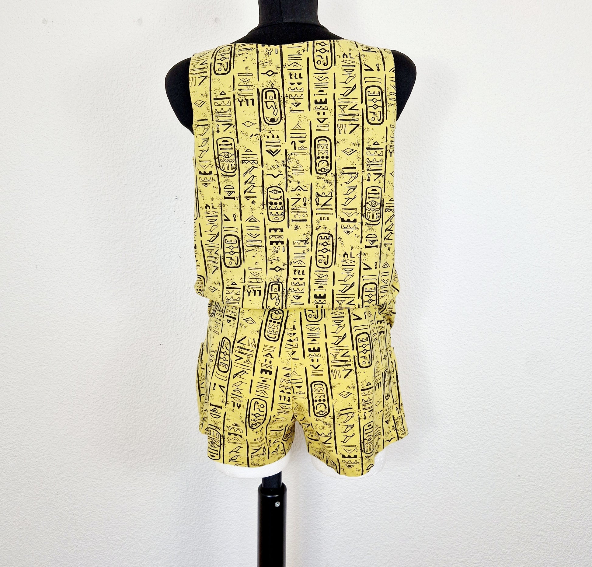 Einzigartiger und nachhaltiger Vintage Playsuit in gelb-schwarz mit Hieroglyphen. Unique and sustainable vintage playsuit in yellow-black with hieroglyphics. Back.